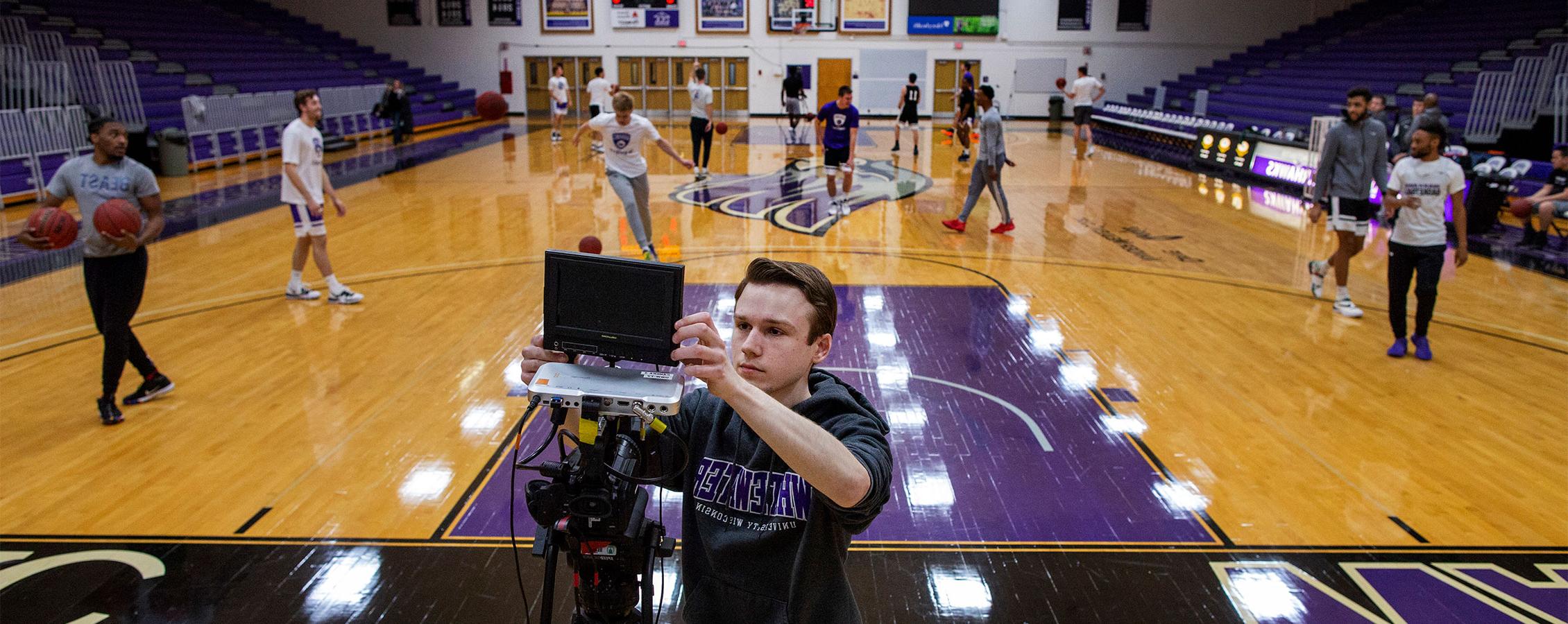  Student sets up camera to broadcast a basketball game at 足彩平台.