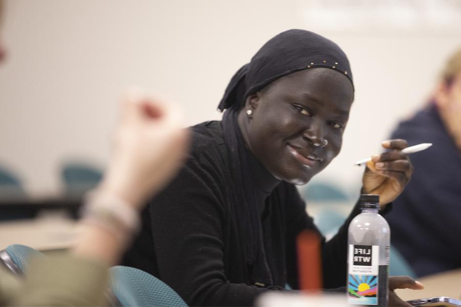 A student smiles in a classroom.