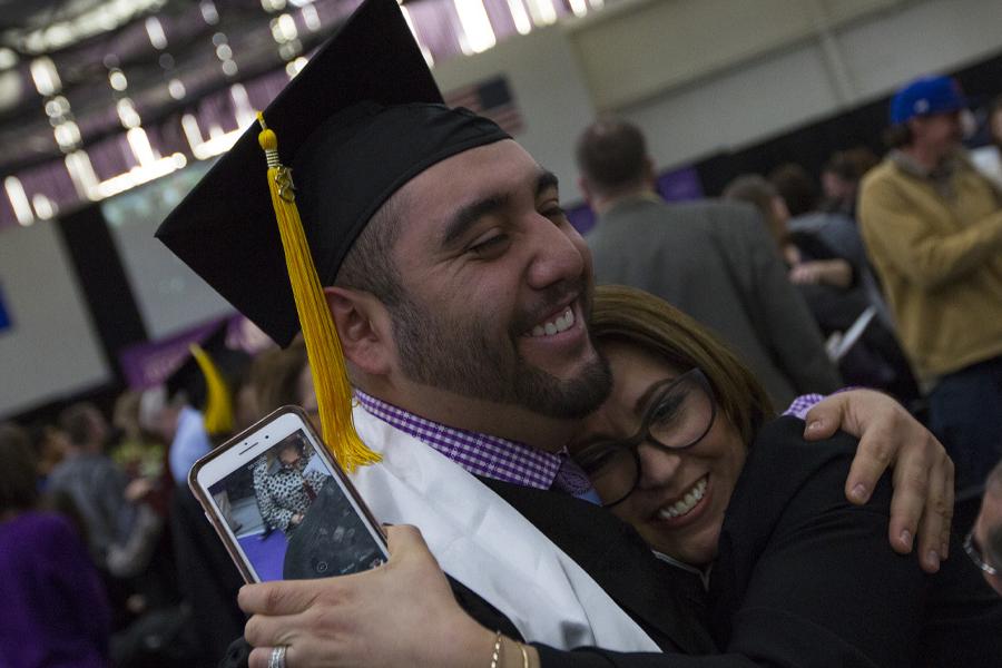 A student hugs their mom at graduation.