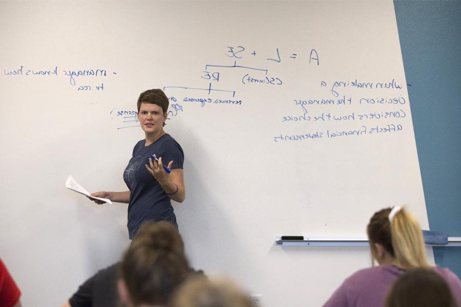 A faculty member teaches at a whiteboard.