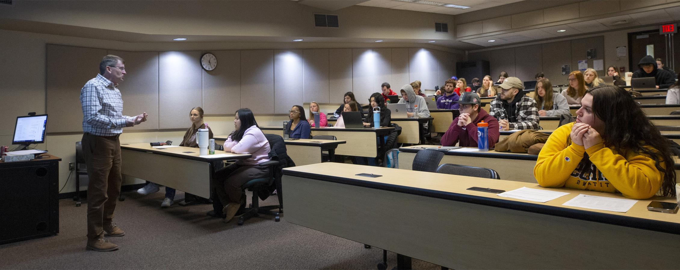 A faculty member teaches at the front of a special education class.