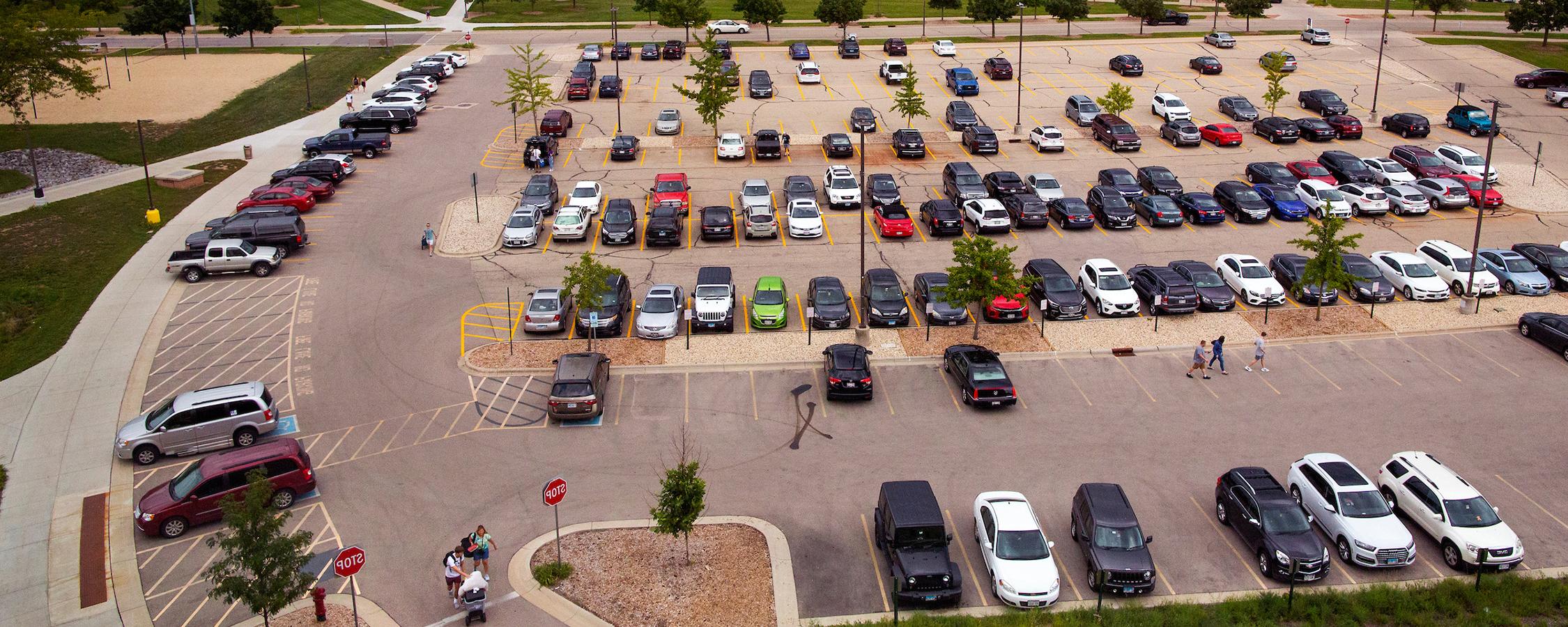 Aerial photo of a parking lot with many cars parked in spaces.