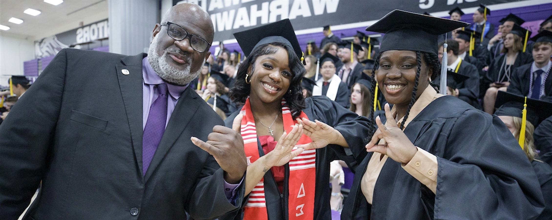 Chancellor King poses with two adult graduates