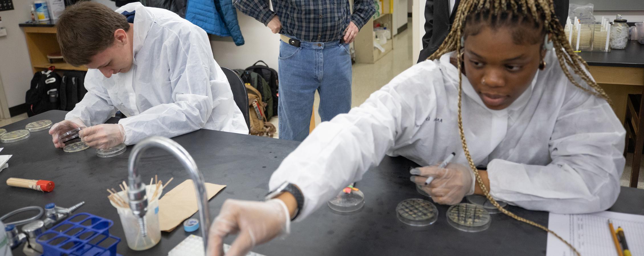 An international student from Nigeria works in a science lab.