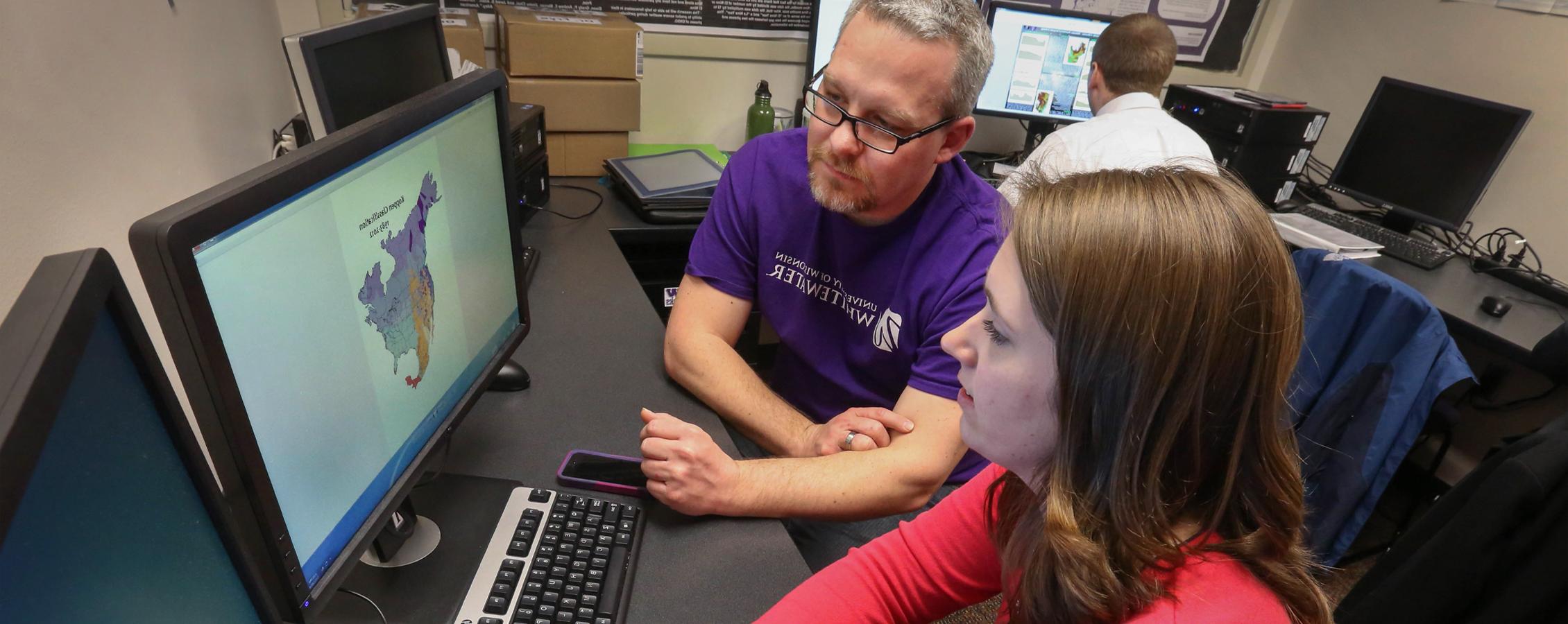 John Frye works with a student at a computer.