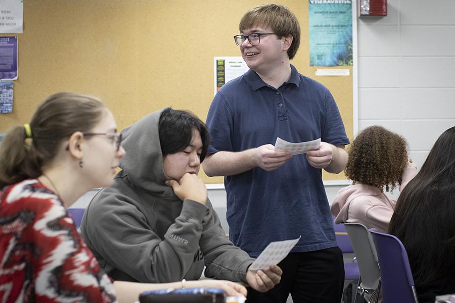 A student smiles as he stands in a classroom.