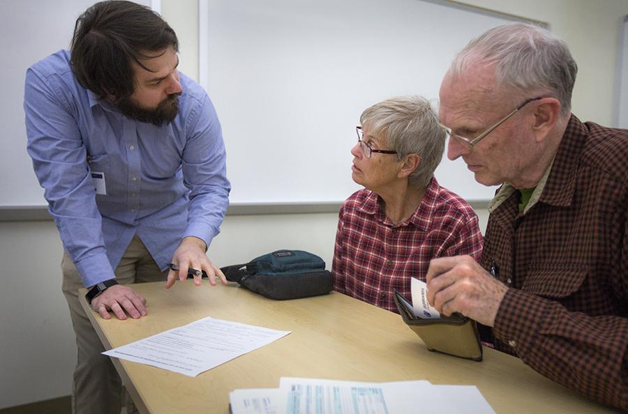 A person helps a couple with their taxes.