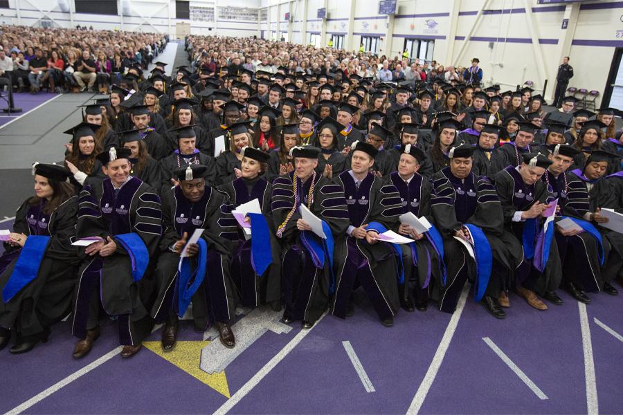 Members of the first cohort of Doctor of Business Administration graduates sit in the front row at Commencement.