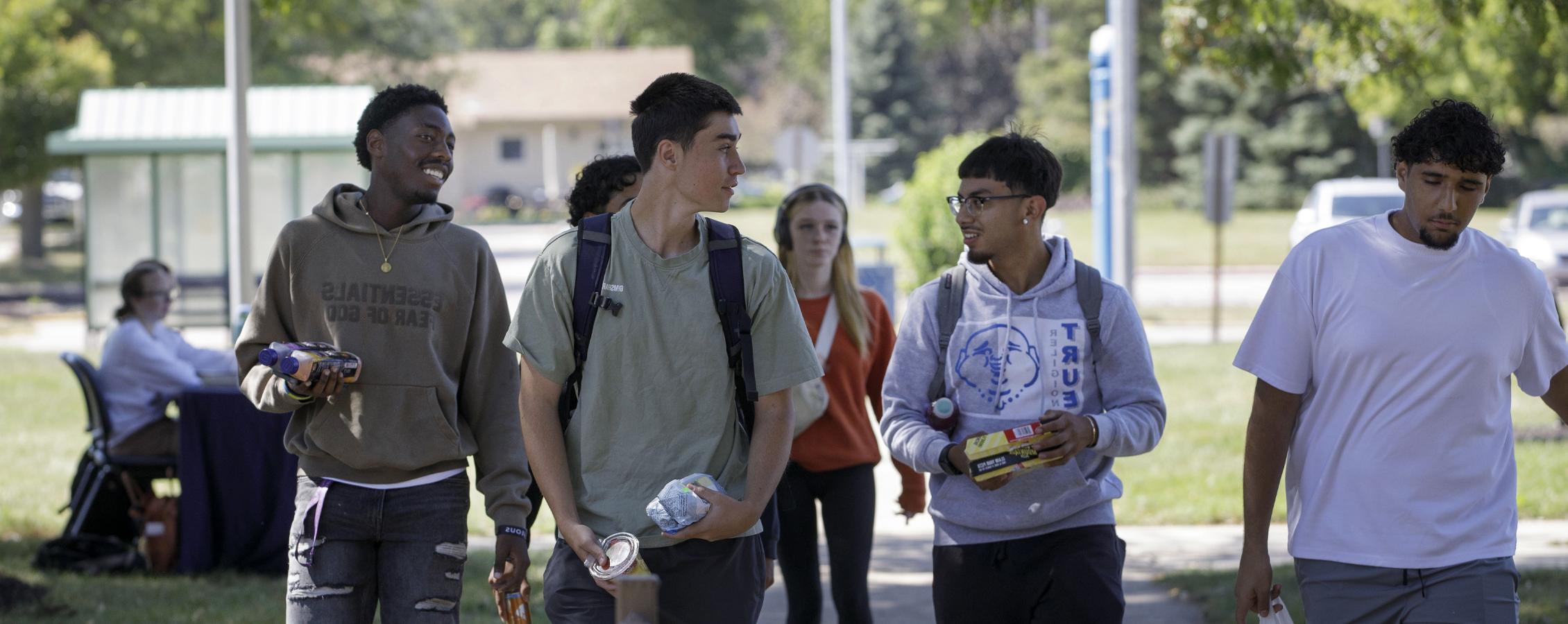 A group of students walk down a sidewalk together.