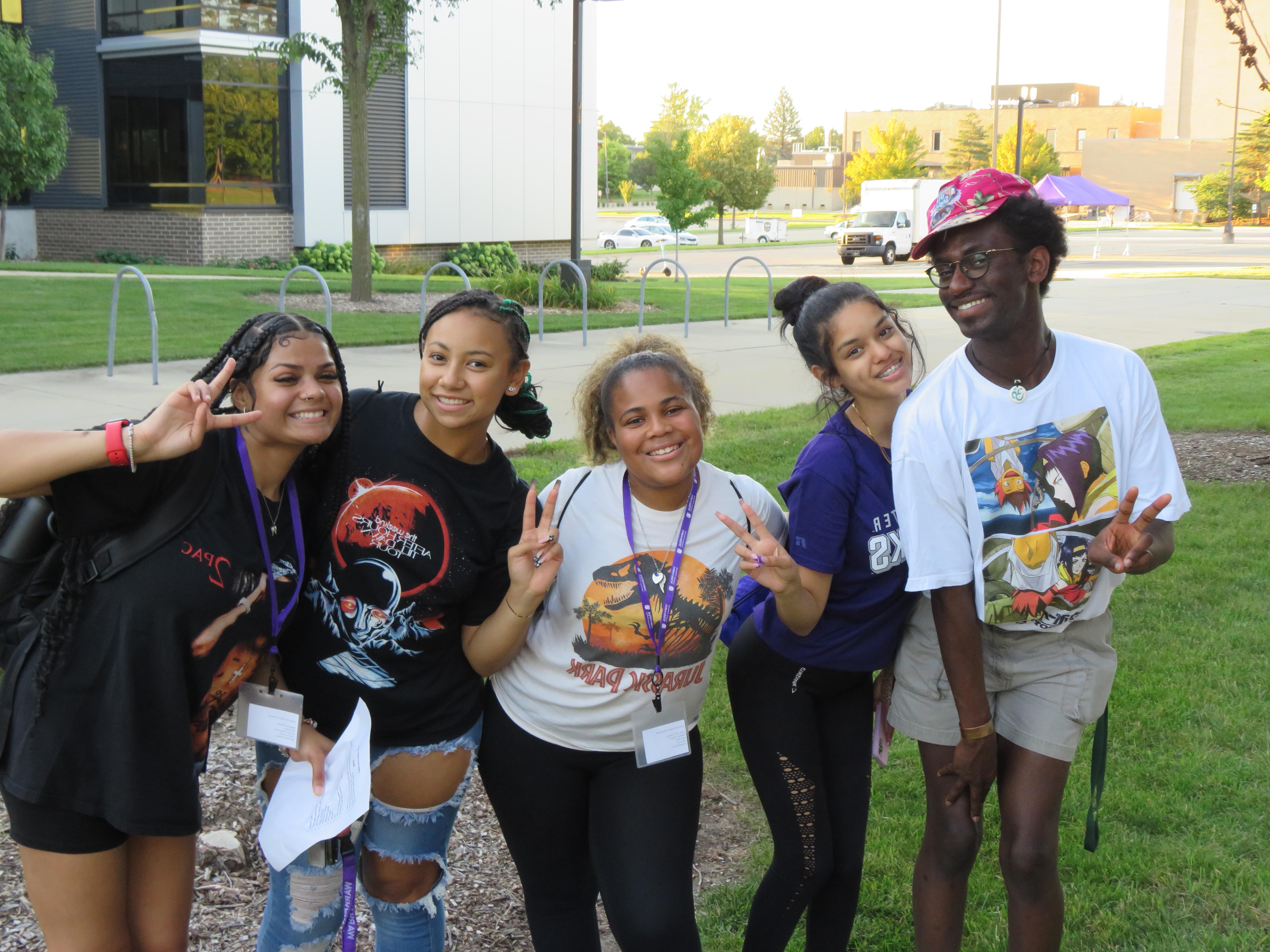 Five students gather together and smile at the camera.